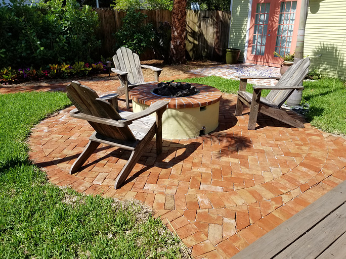 Three chairs on clay pavers in backyard