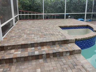 A pool deck with brick pavers